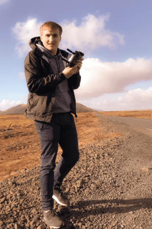 W&学生罗伯特·凯泽站在沙漠中，手里拿着一个机械装置.